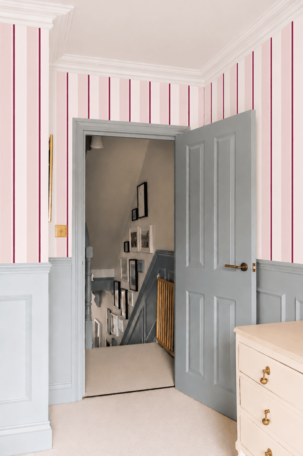 Échantillon du papier peint rayures roses et bordeaux couloir chambre avec porte grise et commode papier peint Marguaux